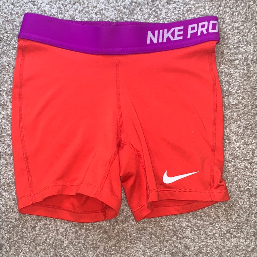 Red/orange Nike Pro Shorts with purple waistband